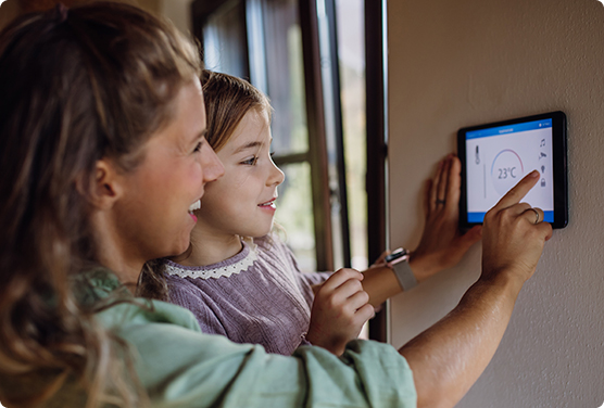  Mother and daughter using WiFi to adjust their thermostat