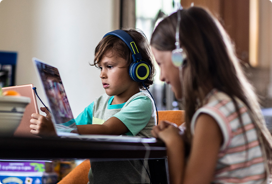 Children using a laptop and tablet to stream videos